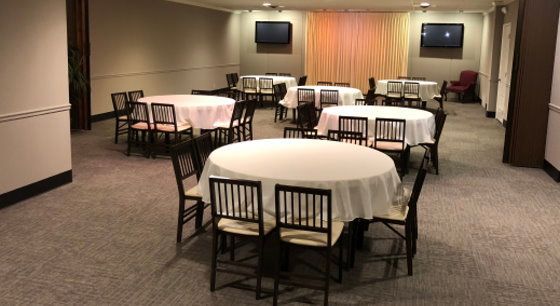 A room with tables and chairs set up for a party.