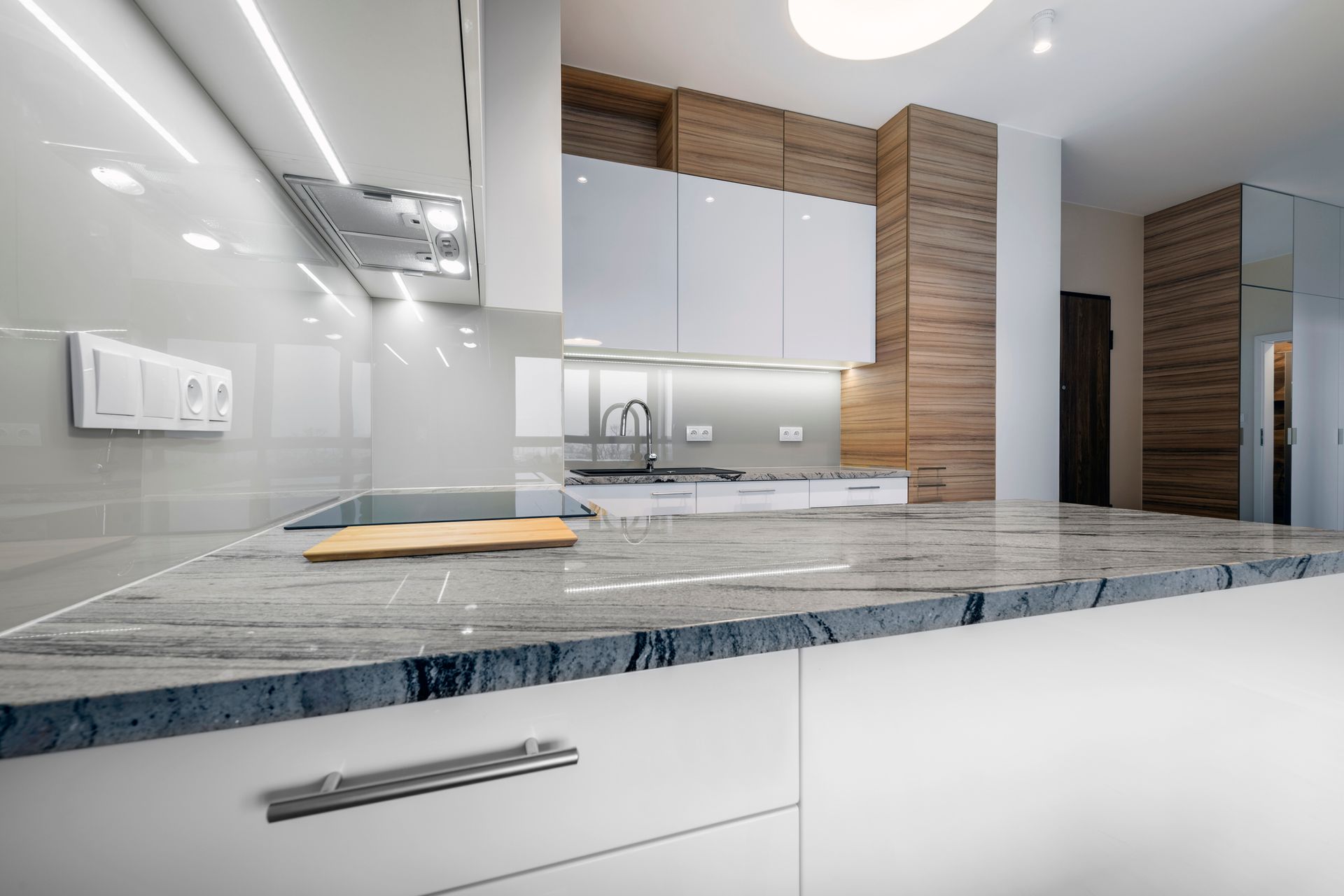 A kitchen with white cabinets and a granite counter top.