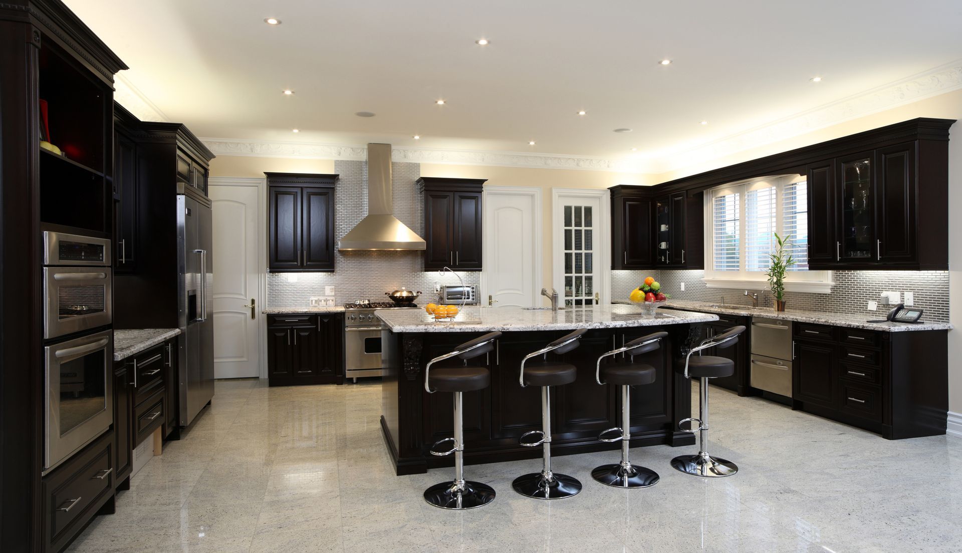 A large kitchen with black cabinets and stainless steel appliances