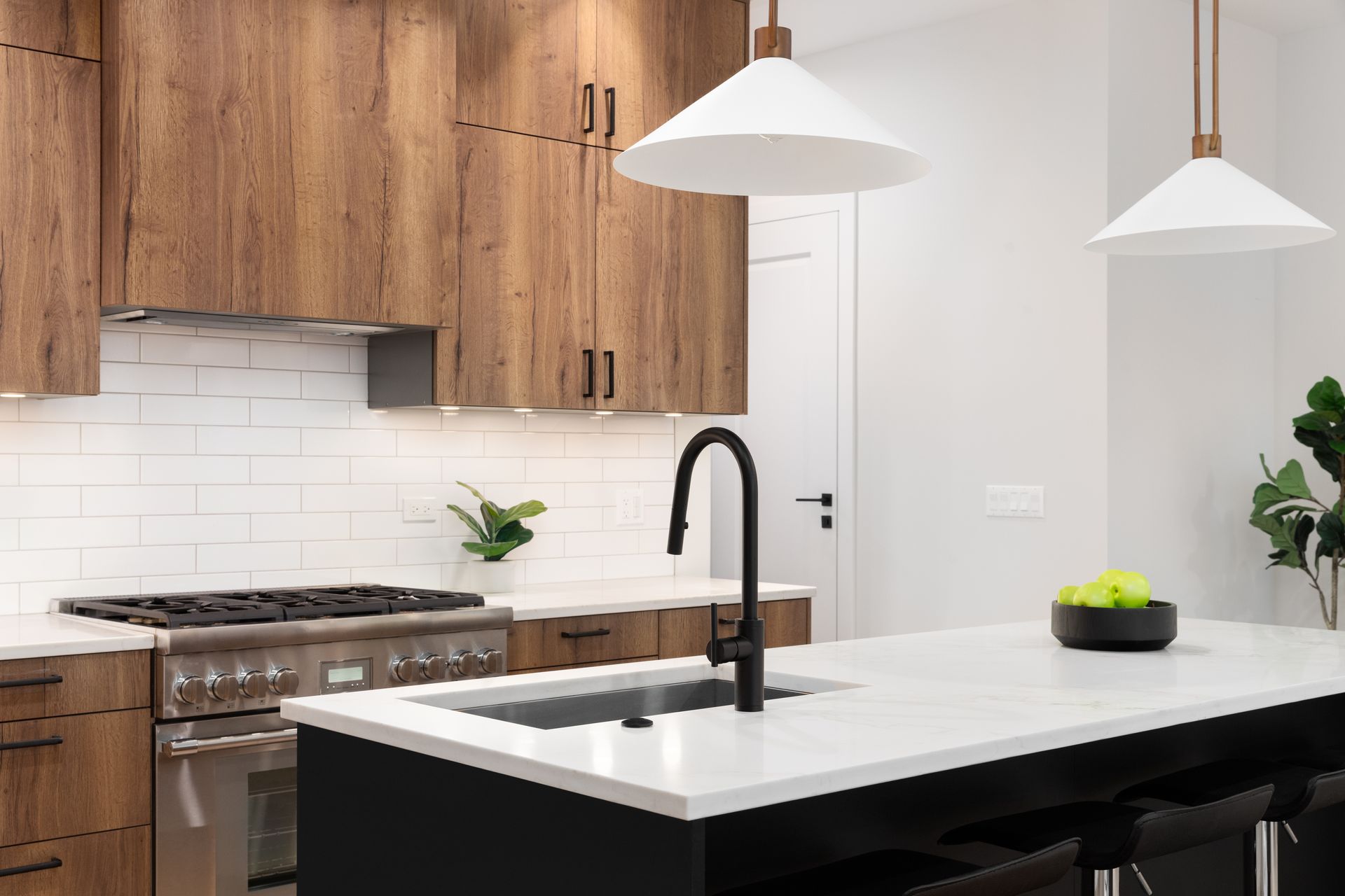A kitchen with wooden cabinets , stainless steel appliances , a sink , and a stove.