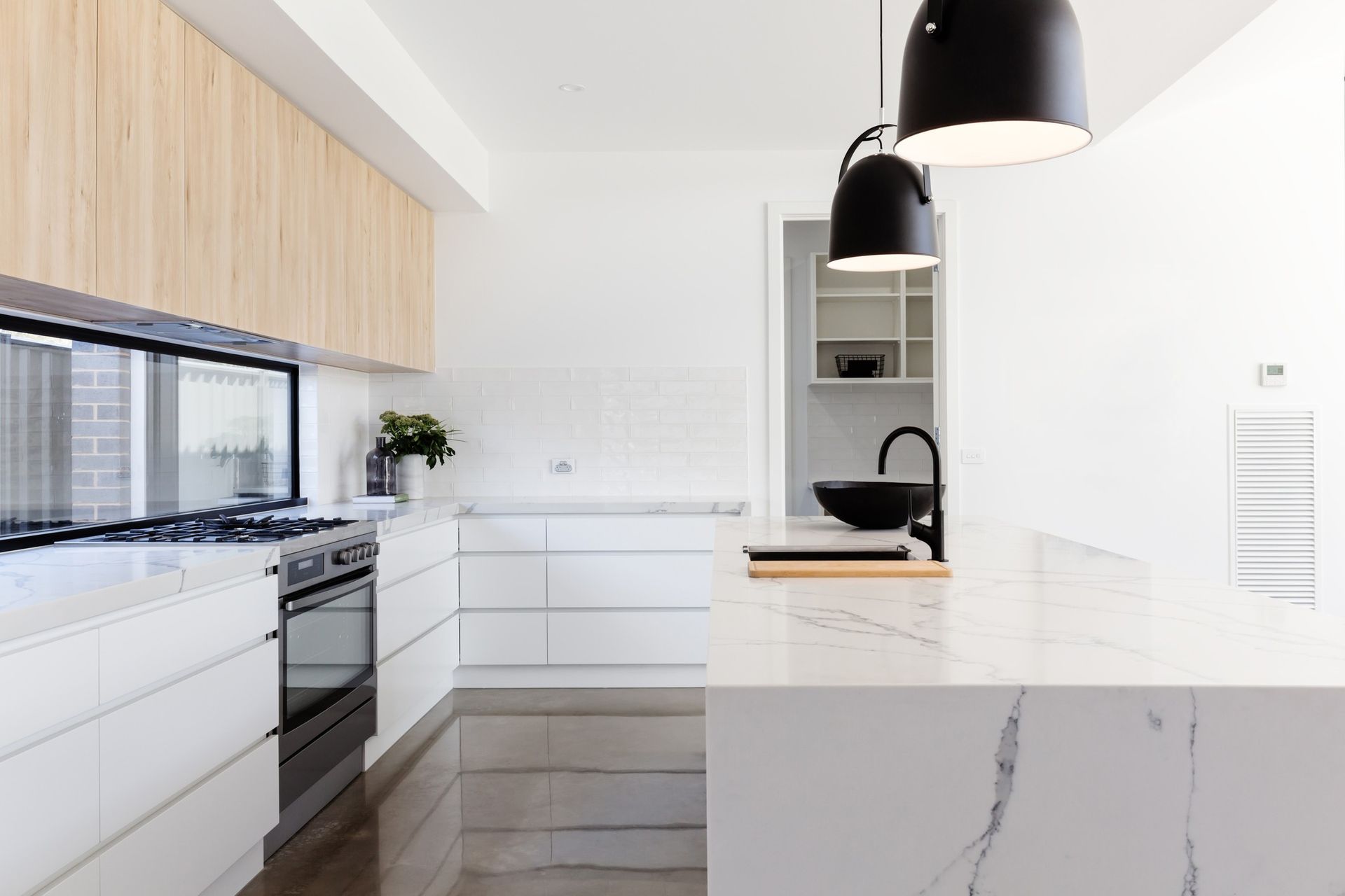 A kitchen with white cabinets and a marble counter top.