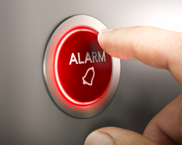 A person is pressing an alarm button with their finger