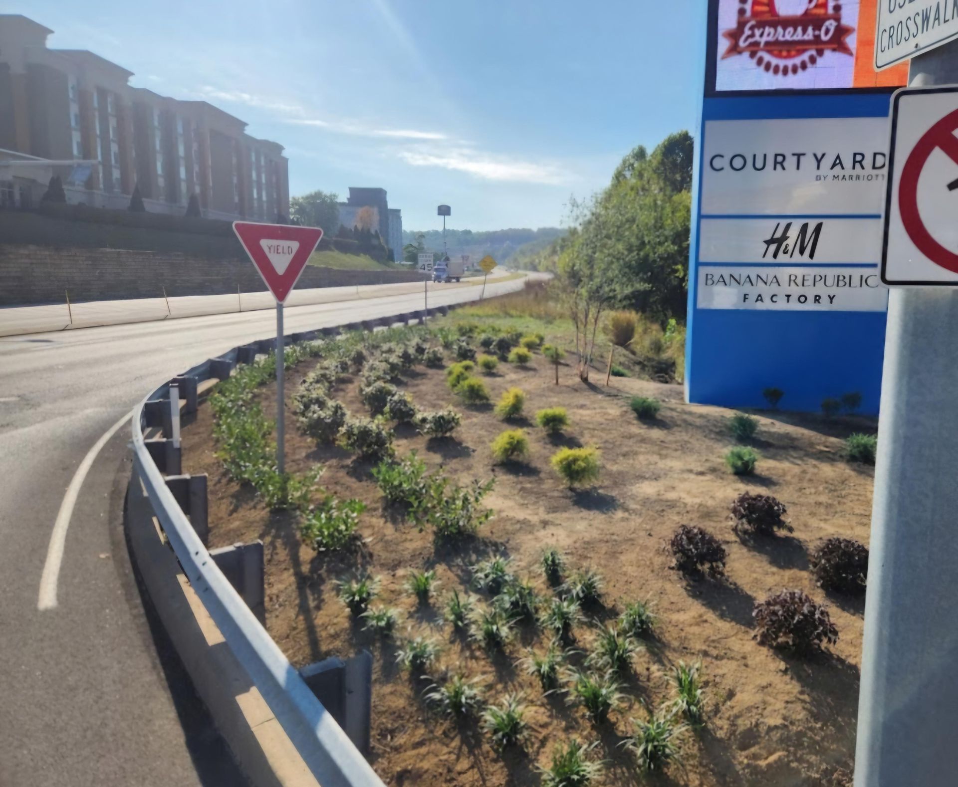 A sign that says courtyard on it next to a highway