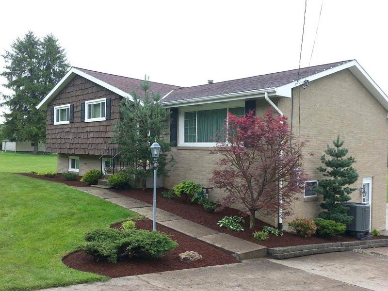 A brick house with a roof that is covered in shingles