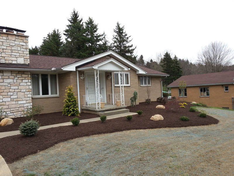 A brick house with a porch and a driveway