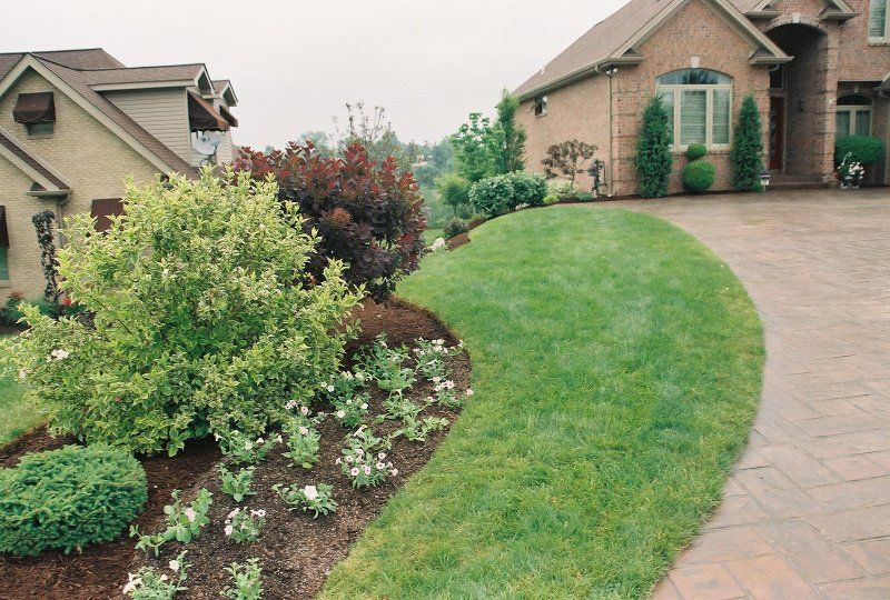 A brick house with a lush green lawn in front of it