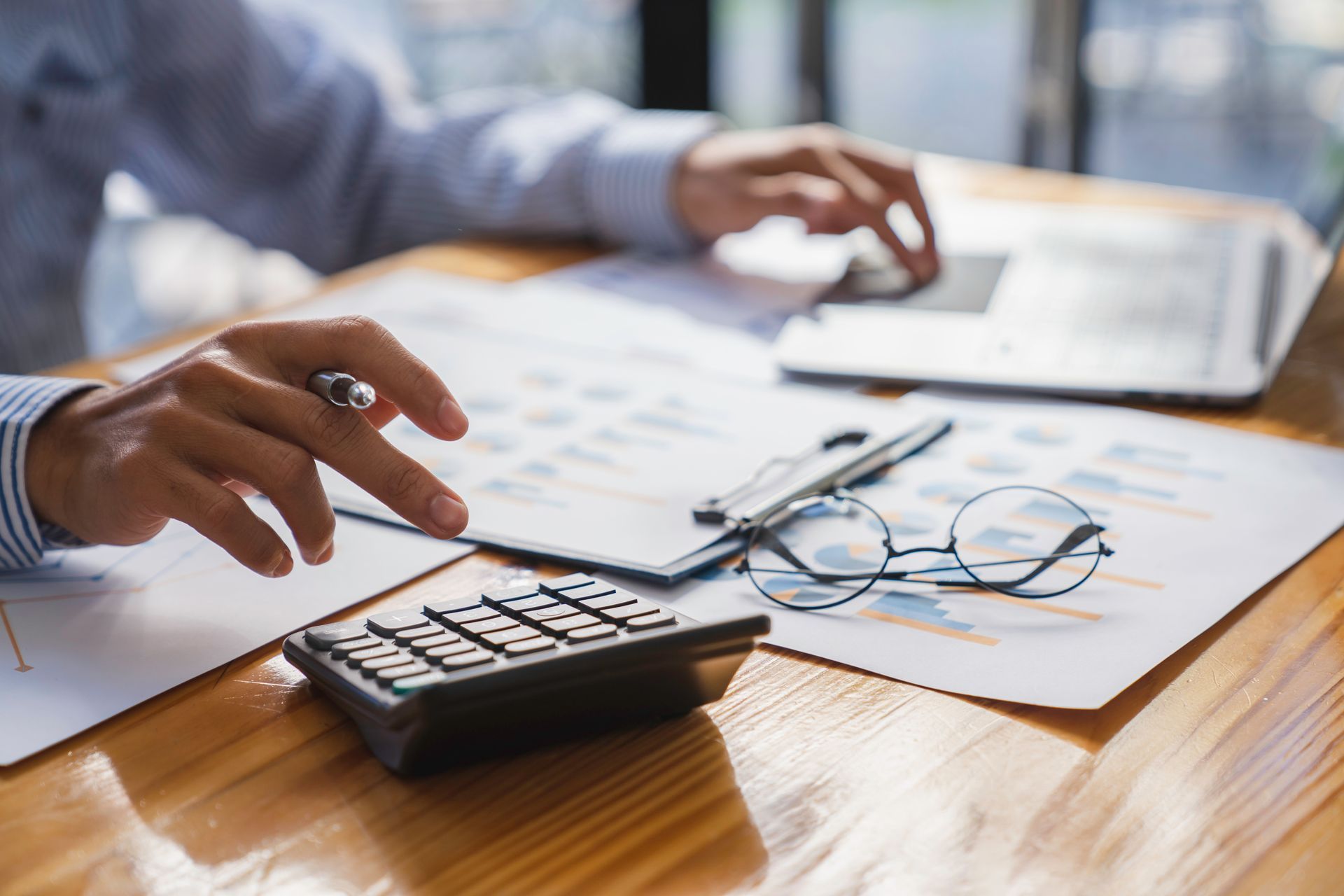 Une personne utilise une calculatrice et la montre du doigt.