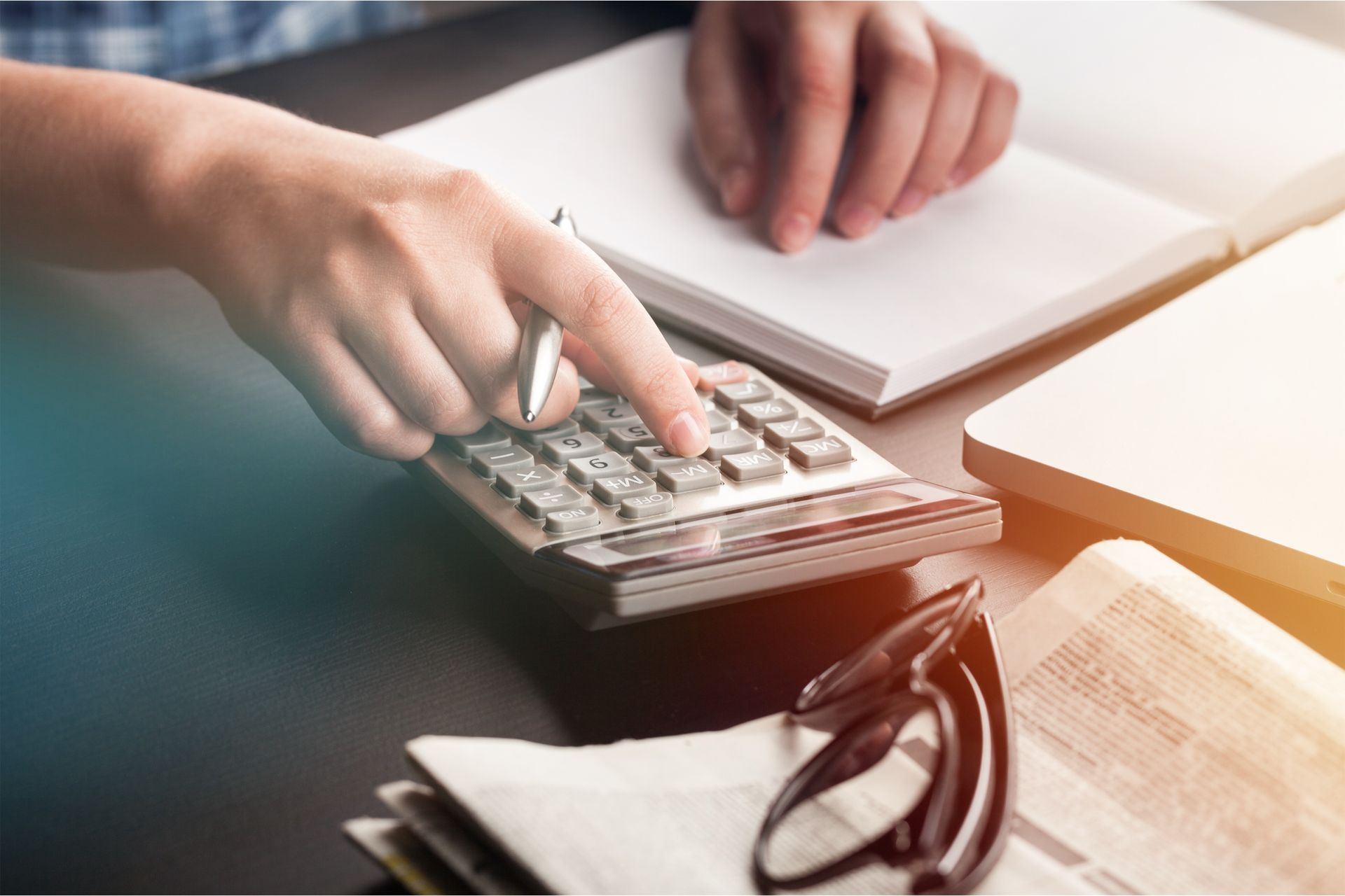 A person is using a calculator and pointing at it.