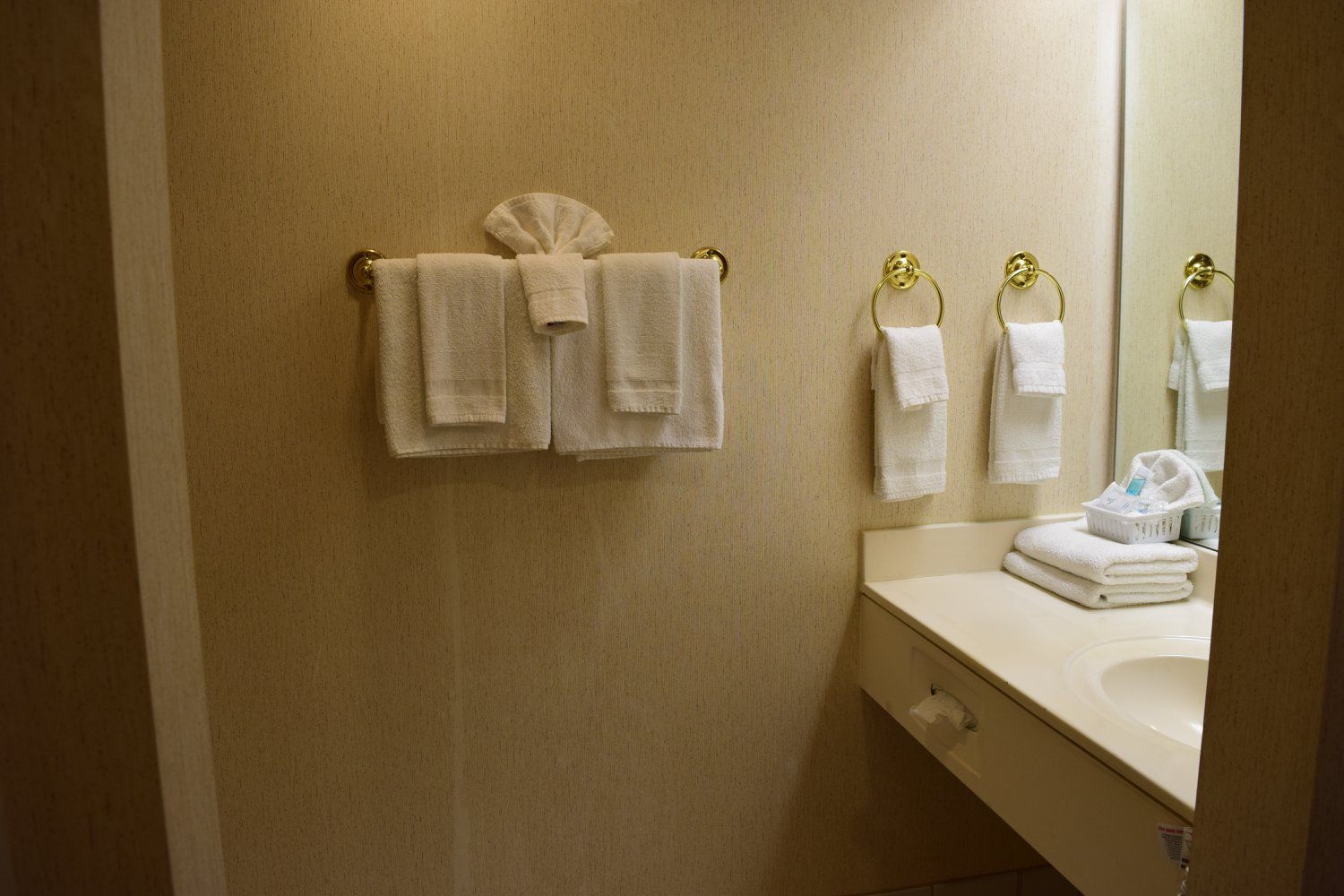 A bathroom with towels hanging on the wall and a sink.