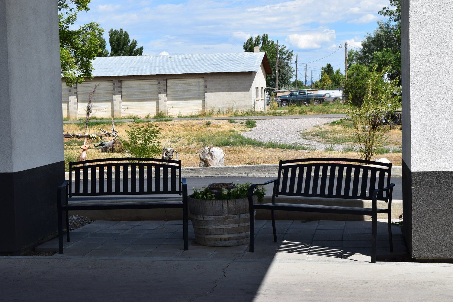 A couple of benches are sitting on a sidewalk in front of a building.