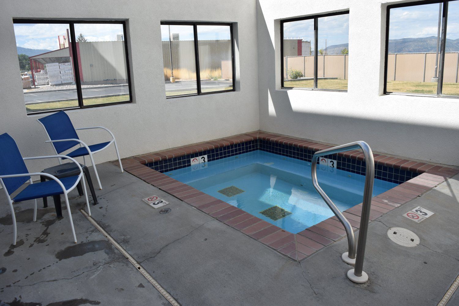 There is a small pool in the middle of the room with chairs.