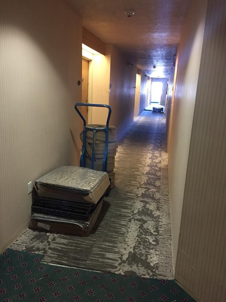 A hallway with a stack of carpet on the floor