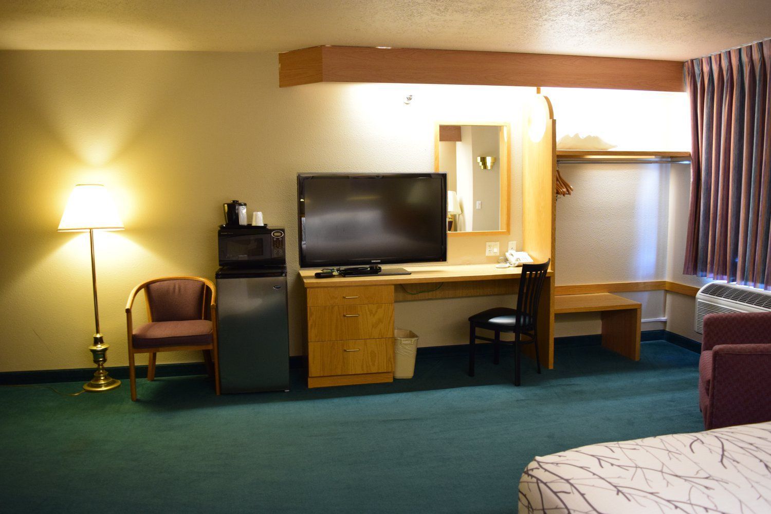 A hotel room with a large flat screen tv on the desk