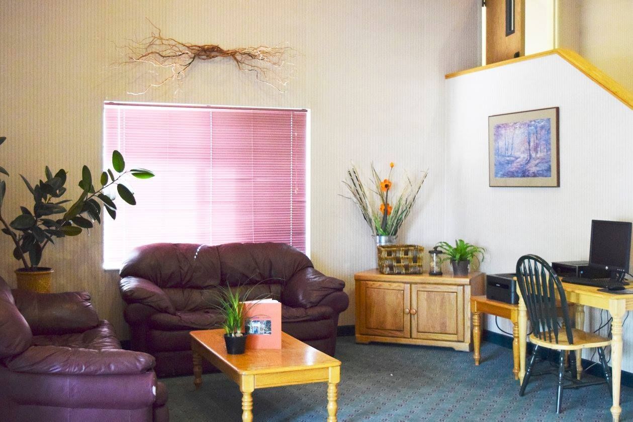 A living room with a couch , chairs , table and computer