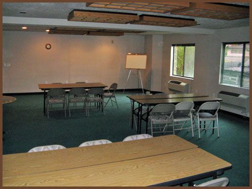 A room with tables and chairs and a white board