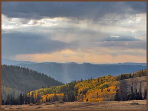 The sun is shining through the clouds over the mountains.