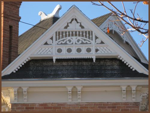 The roof of a house has a triangle shaped decoration on it