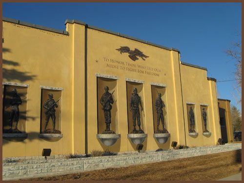 A yellow building with statues of soldiers on the side
