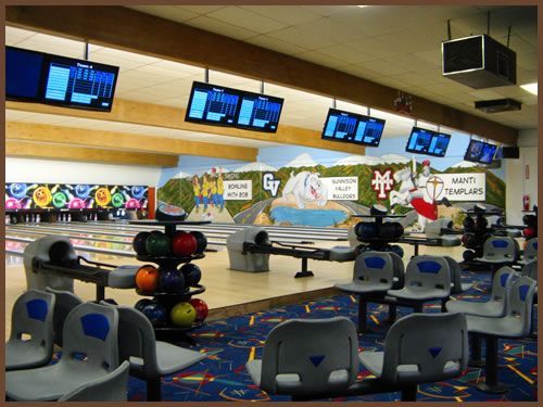 A bowling alley with a mural on the wall that says mc on it