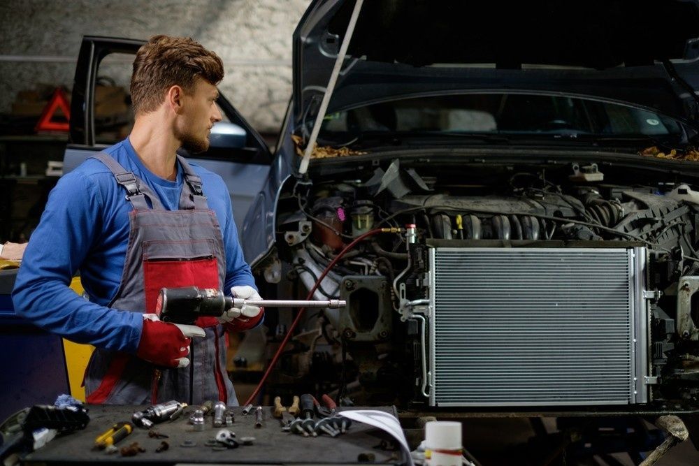 A Man is Working on the Radiator of a Car in a Garage — Neilsen's Radiator Service in Toowoomba City, QLD