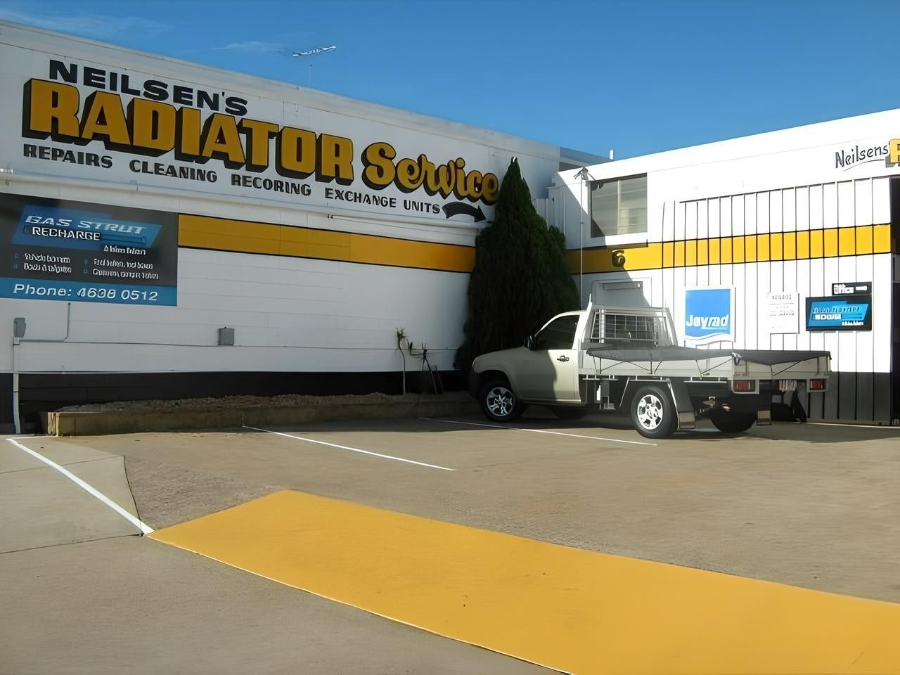 A White Truck is Parked in Front of a Building That Says Radiator Service — Neilsen's Radiator Service in Warwick, QLD