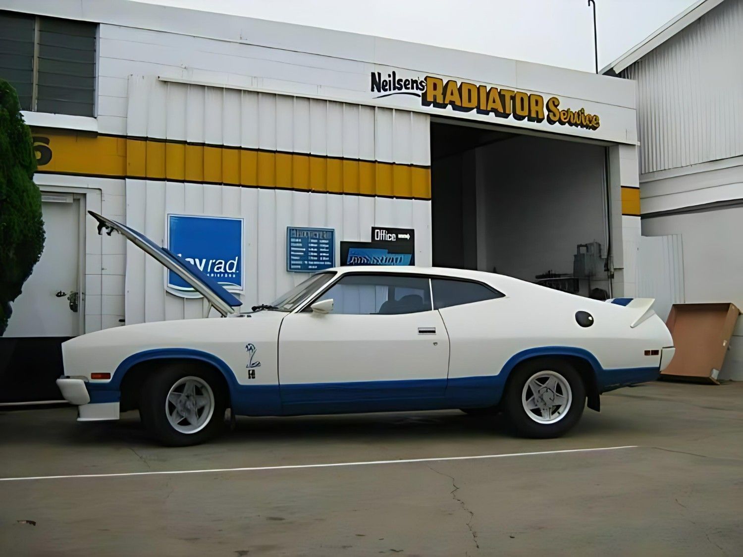 A White and Blue Car is Parked in Front of a Radiator Shop — Neilsen's Radiator Service in Toowoomba City, QLD