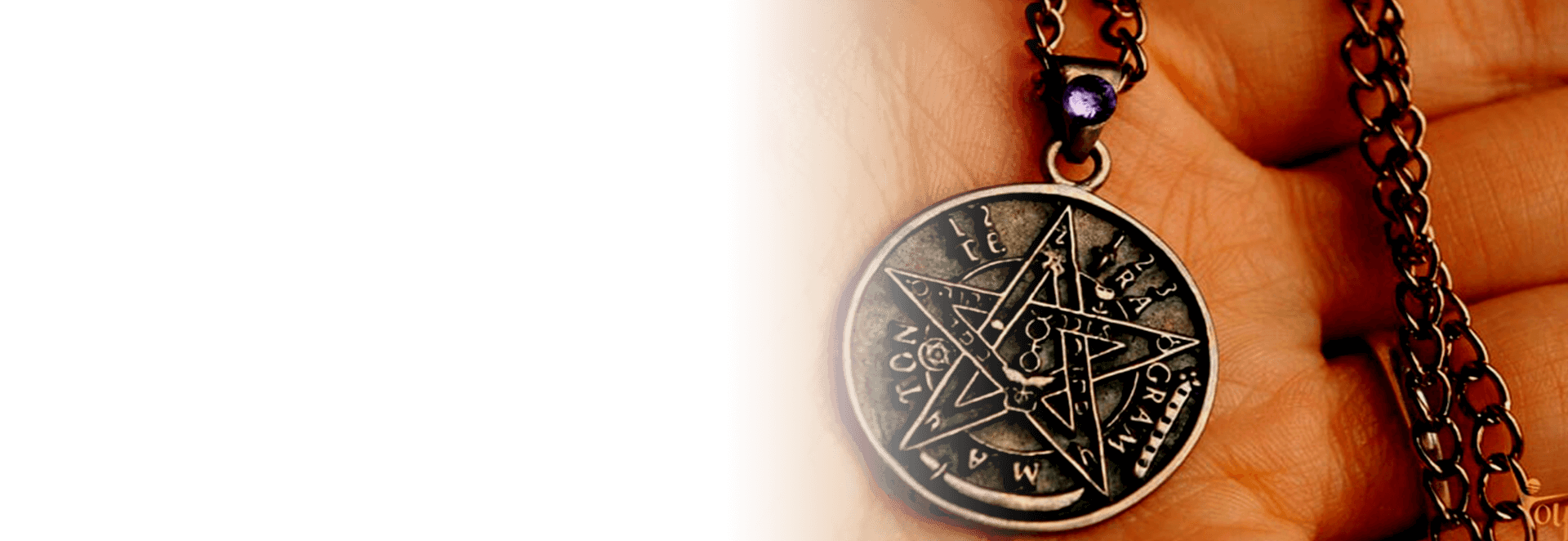 Una persona sostiene un collar con un colgante de pentagrama.