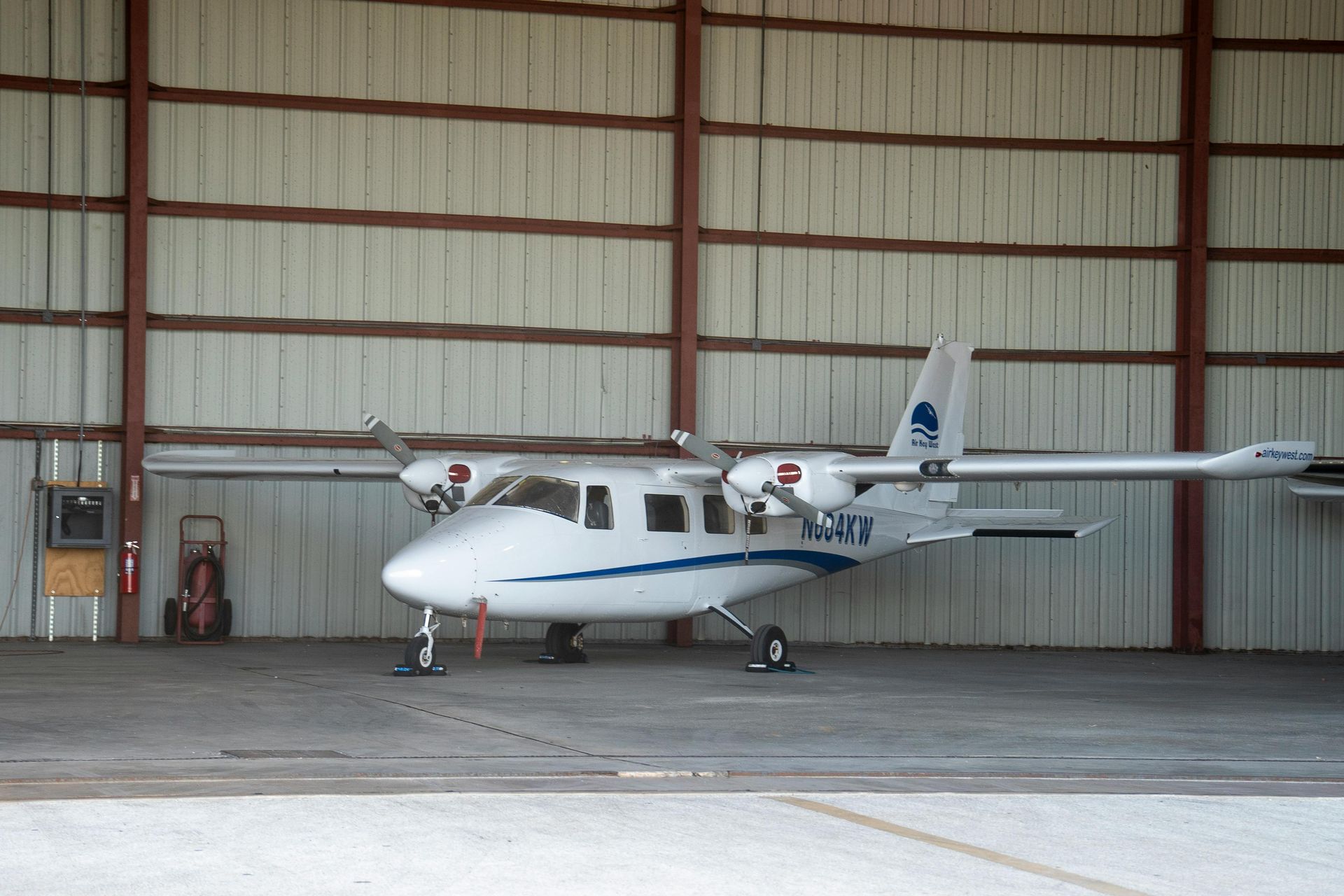 A small plane is parked inside of a hangar