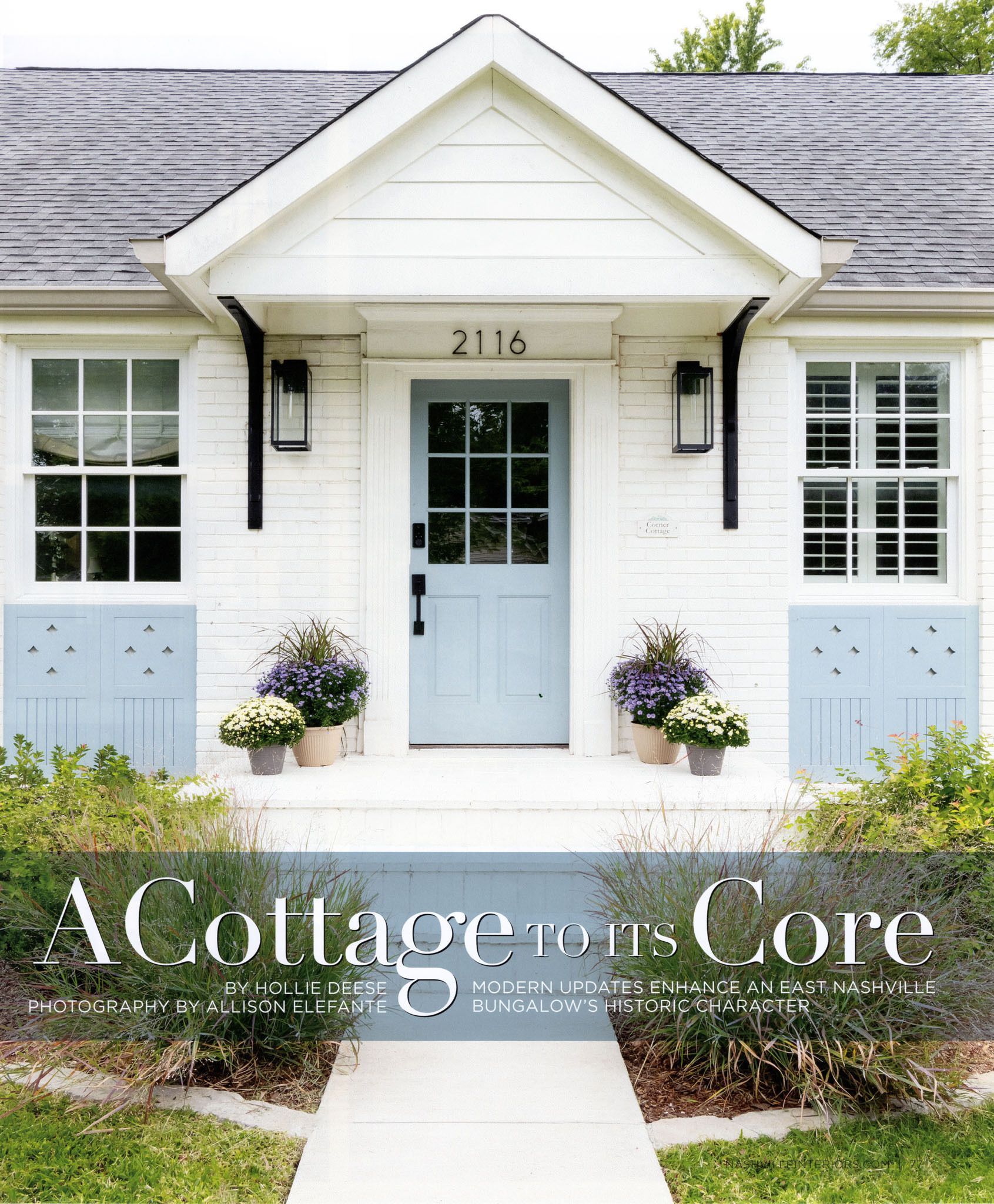 Cottage with blue door, shutters, and flower pots, white facade, black accents, and