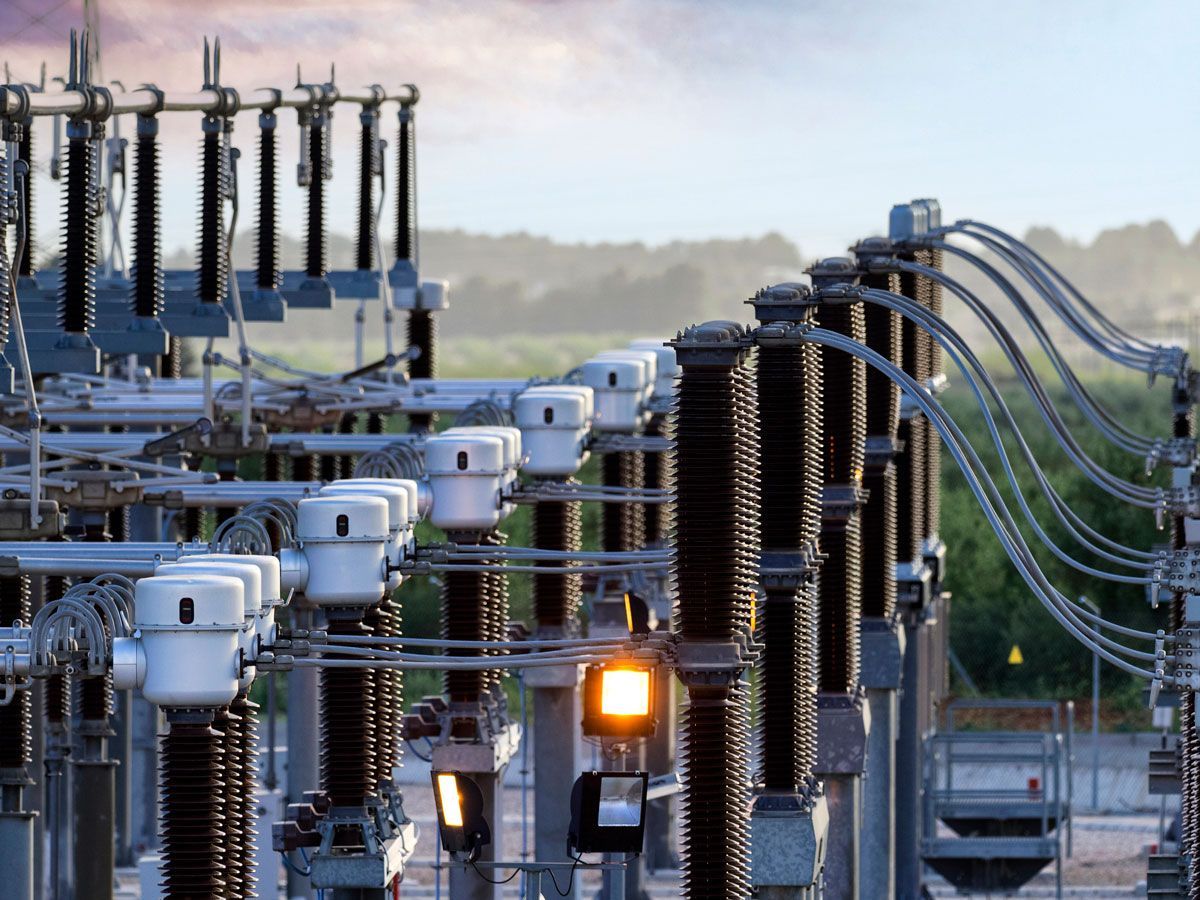 Electrical power substation with tall insulators and wires.