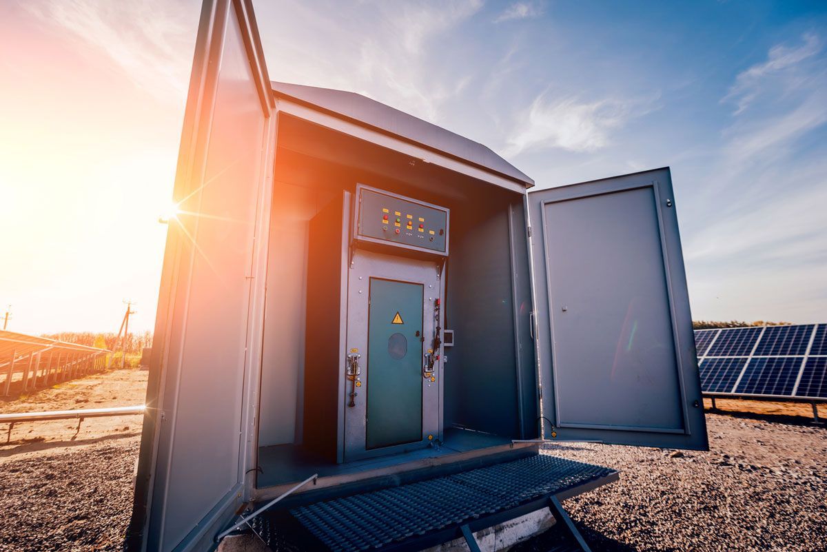 Electrical control box with open doors, blue sky, and solar panels.