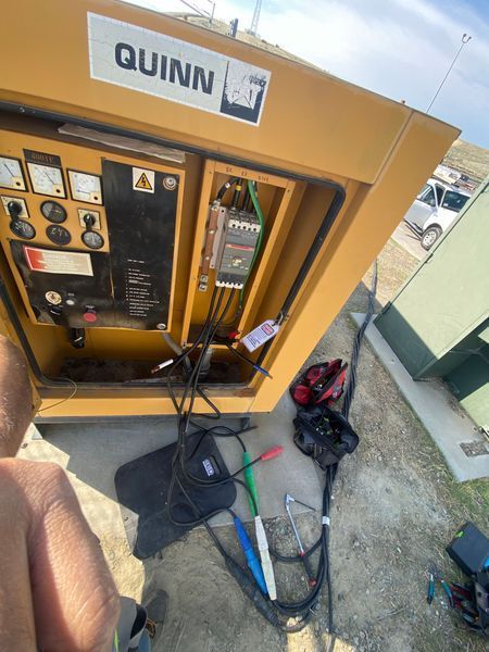 Electrical control box with open doors, blue sky, and solar panels.