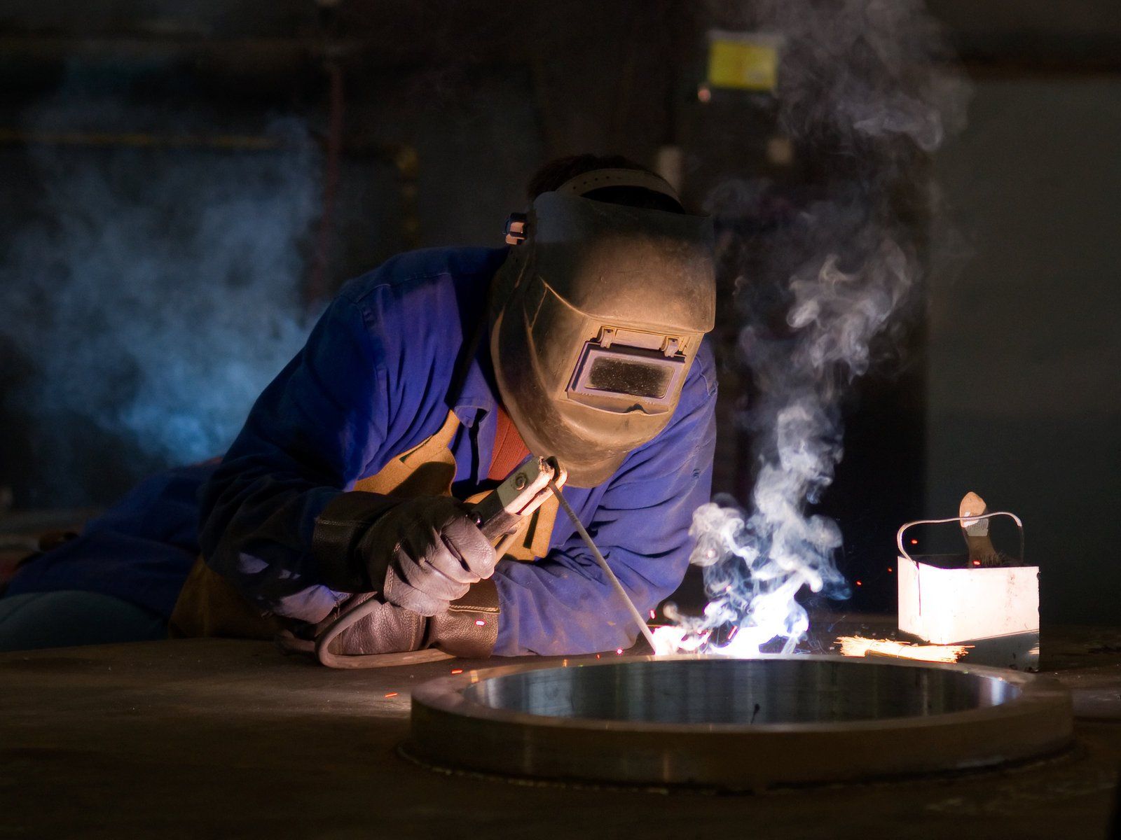 man using welding in metals