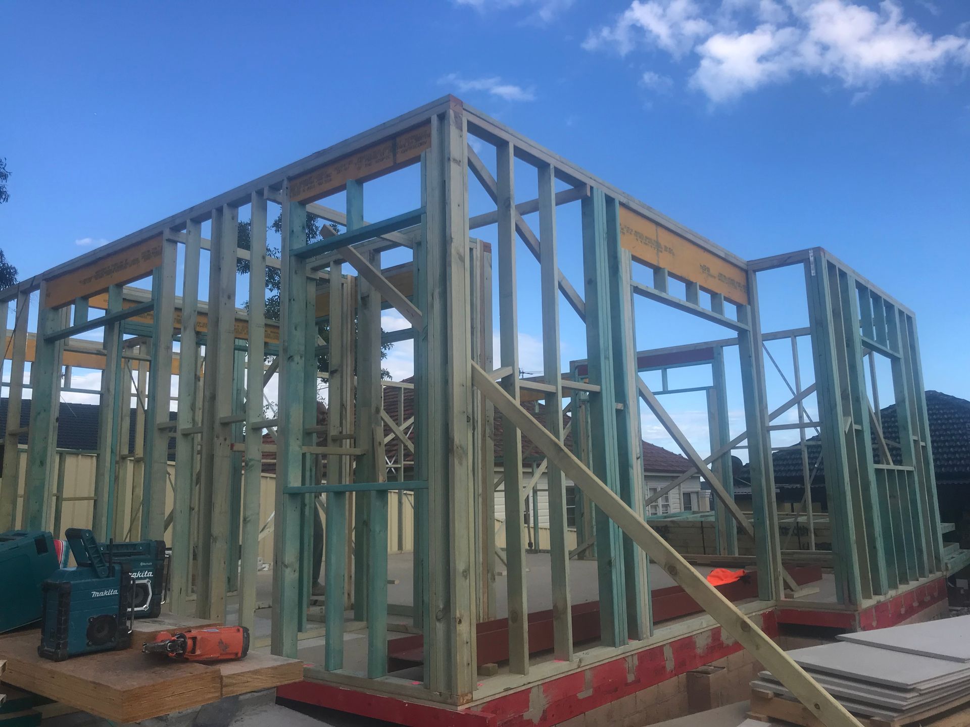 Wooden frame of a building under construction against a blue sky — Keystone Property Solutions In Maitland, NSW