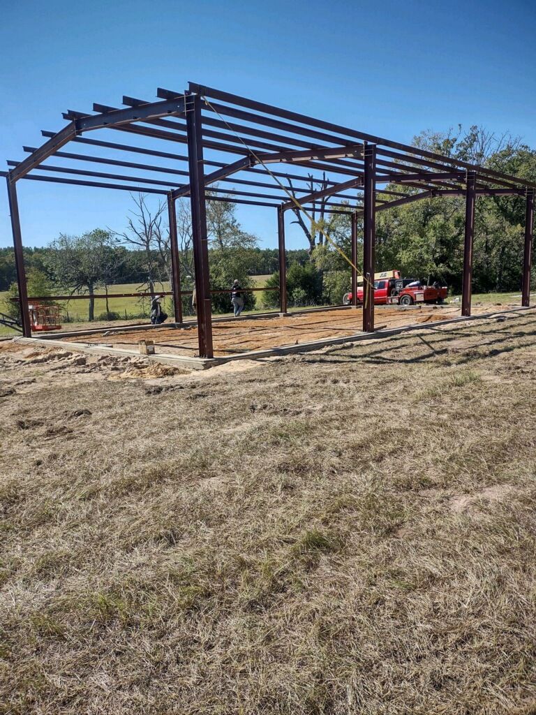 A large metal structure is being built in the middle of a field.