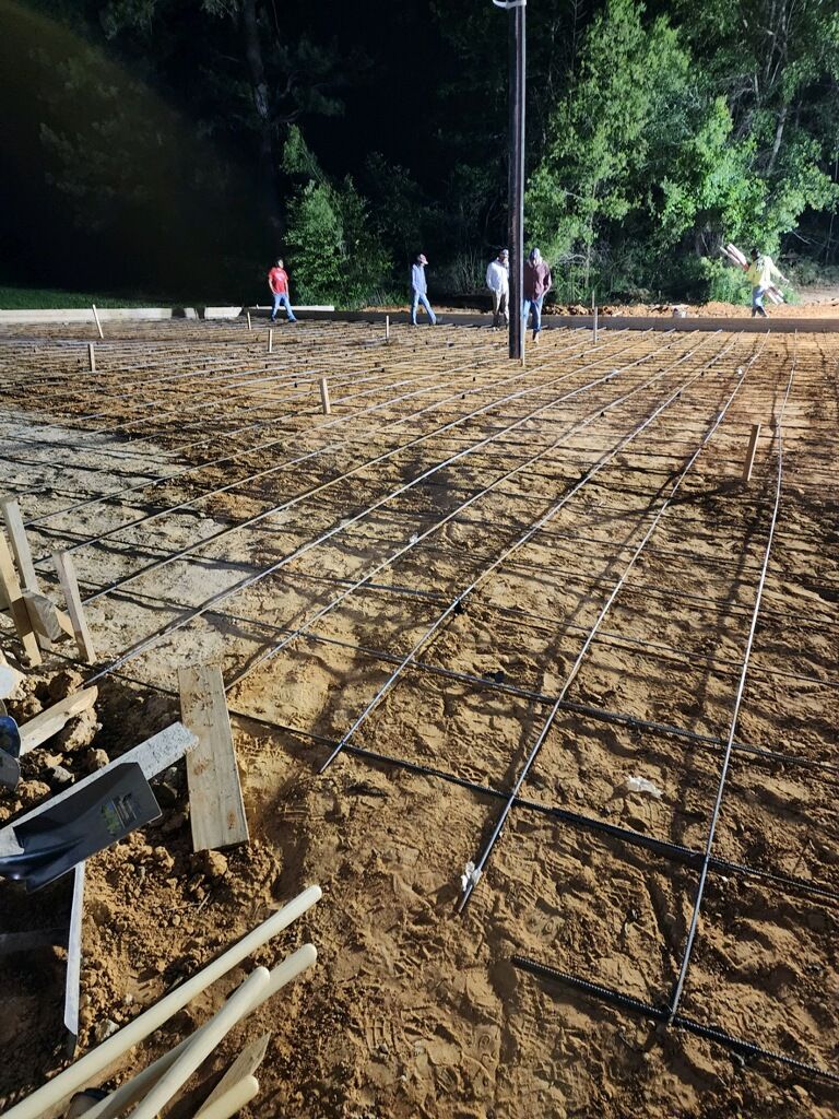 A group of people are standing on top of a dirt field.