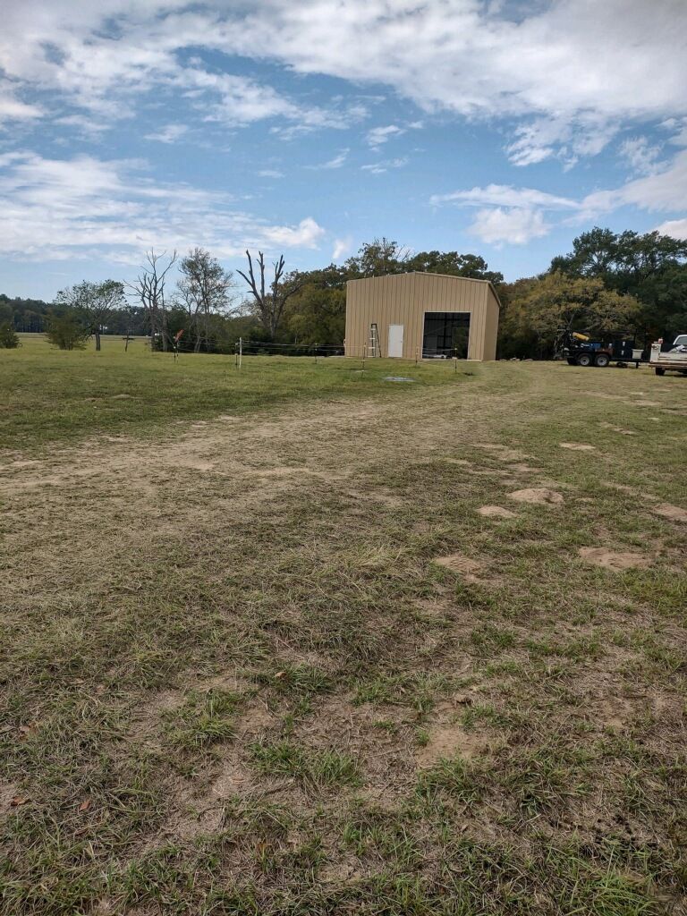 A large grassy field with a building in the background.