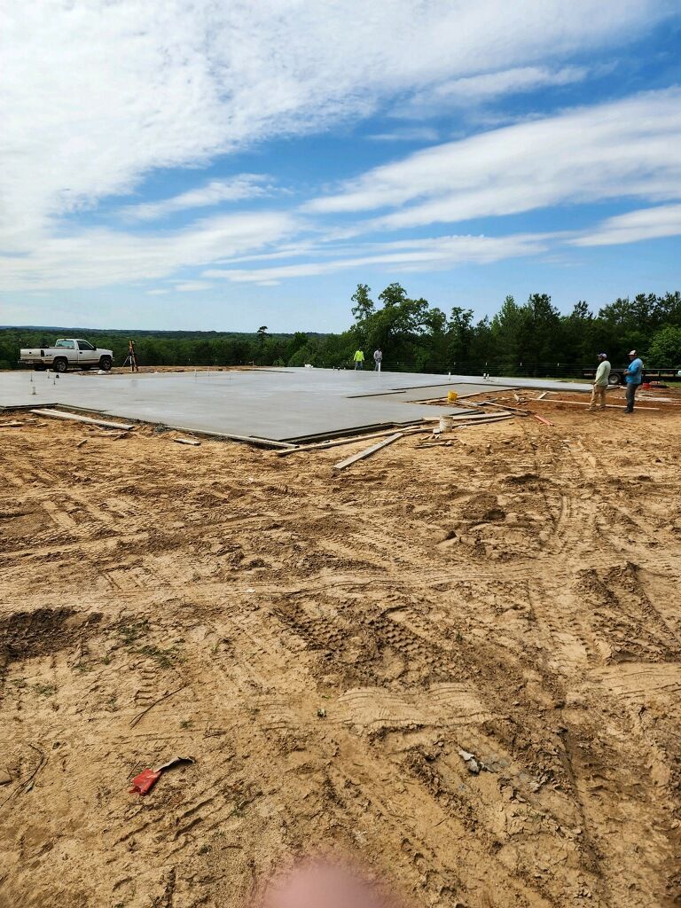 A large concrete slab is being built on a dirt field.