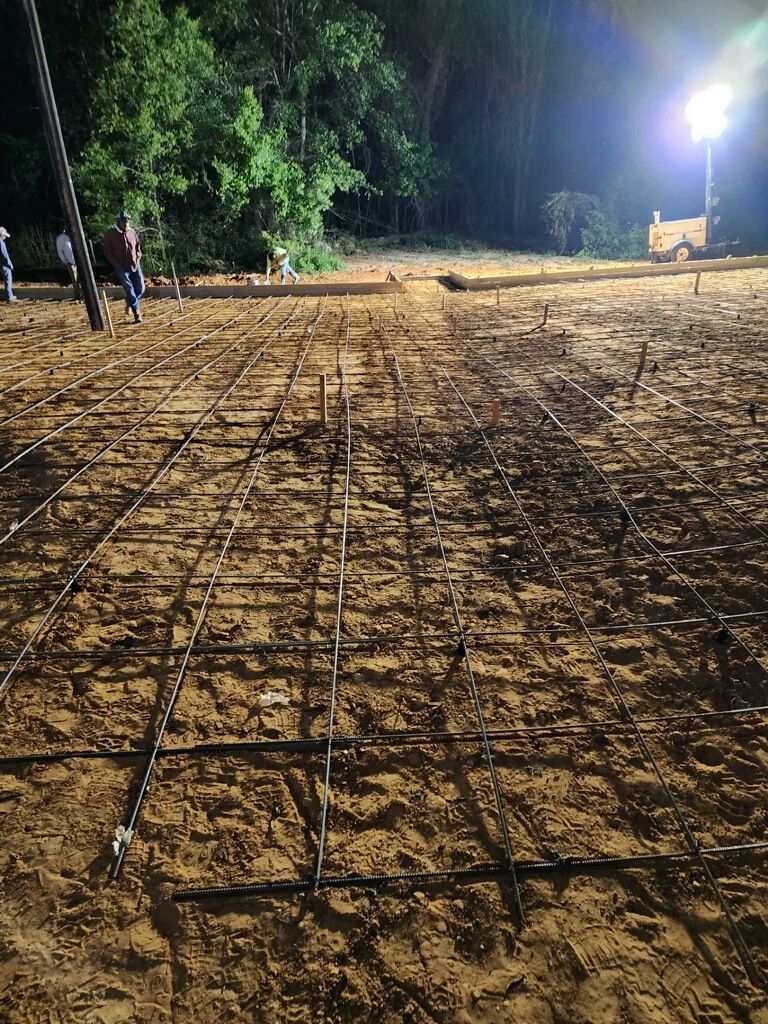 A group of people are working on a construction site at night.