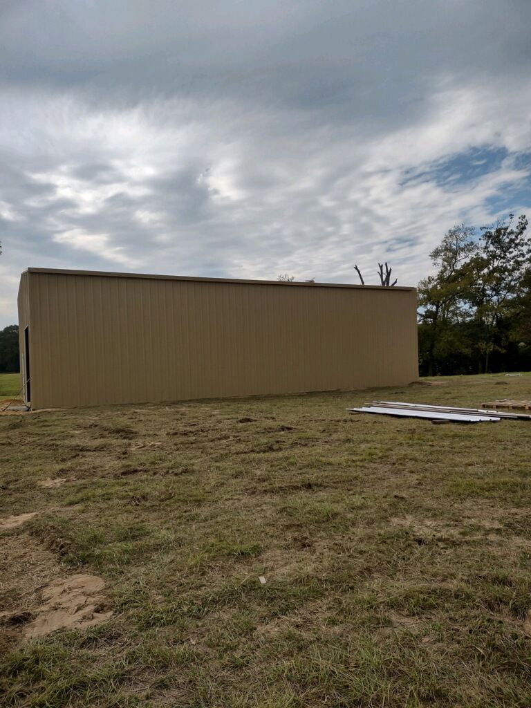 A large building is sitting in the middle of a grassy field.