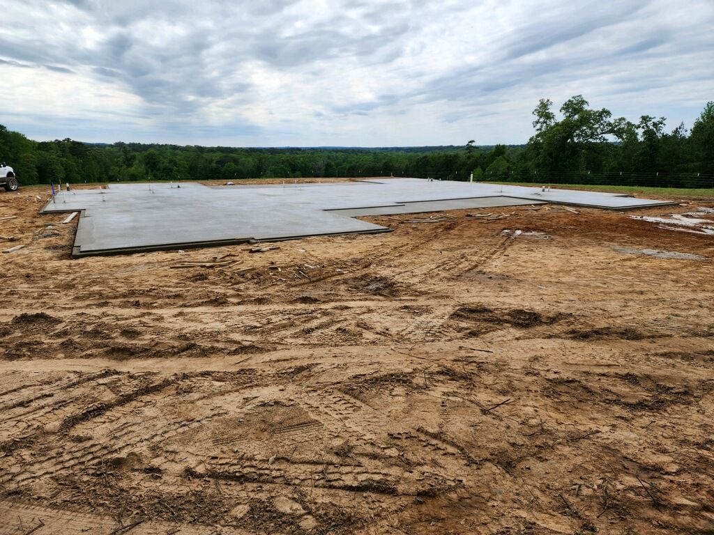A large concrete slab is sitting in the middle of a dirt field.