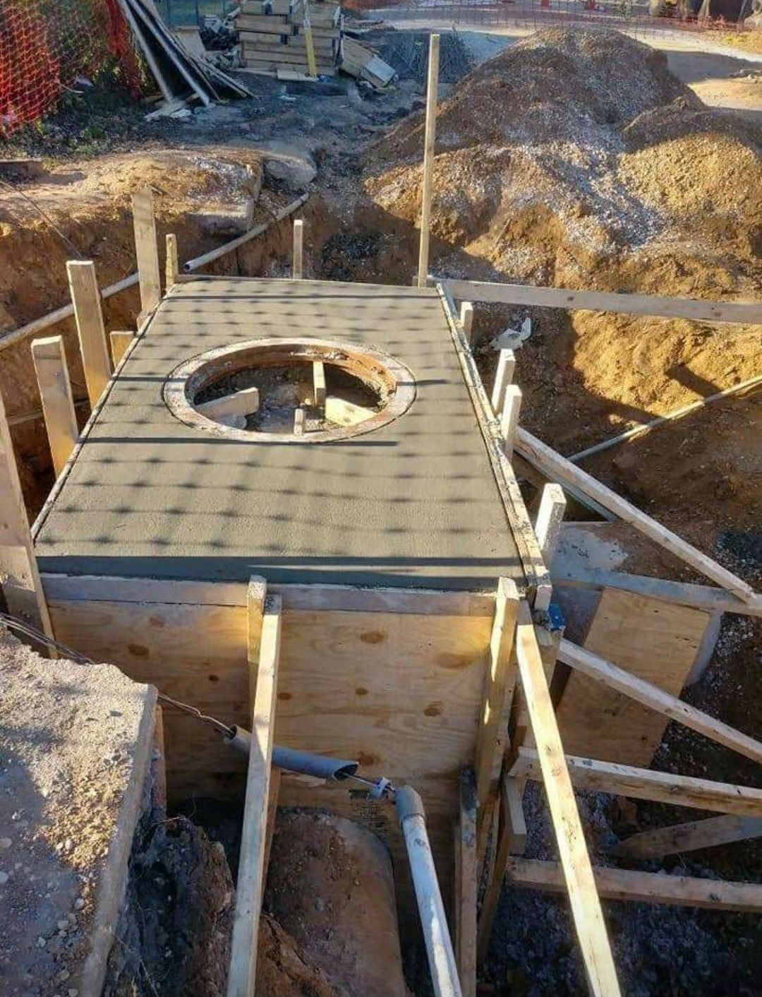 A wooden structure is being built in a hole in the ground.