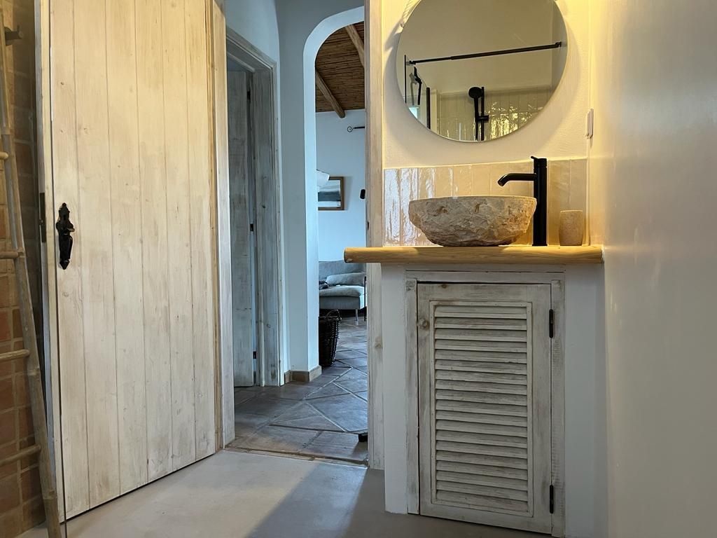 Een badkamer met een wastafel en een spiegel aan de muur.