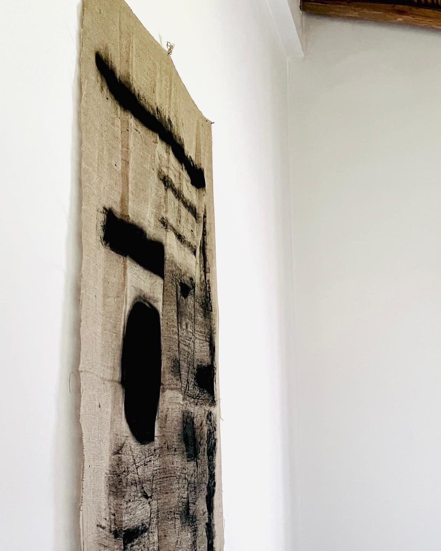 A painting is hanging on a white wall in a room.