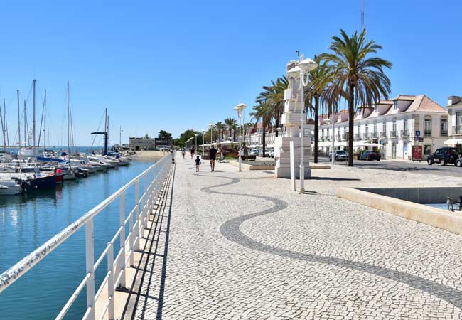 Een rij boten ligt aangemeerd in een haven.