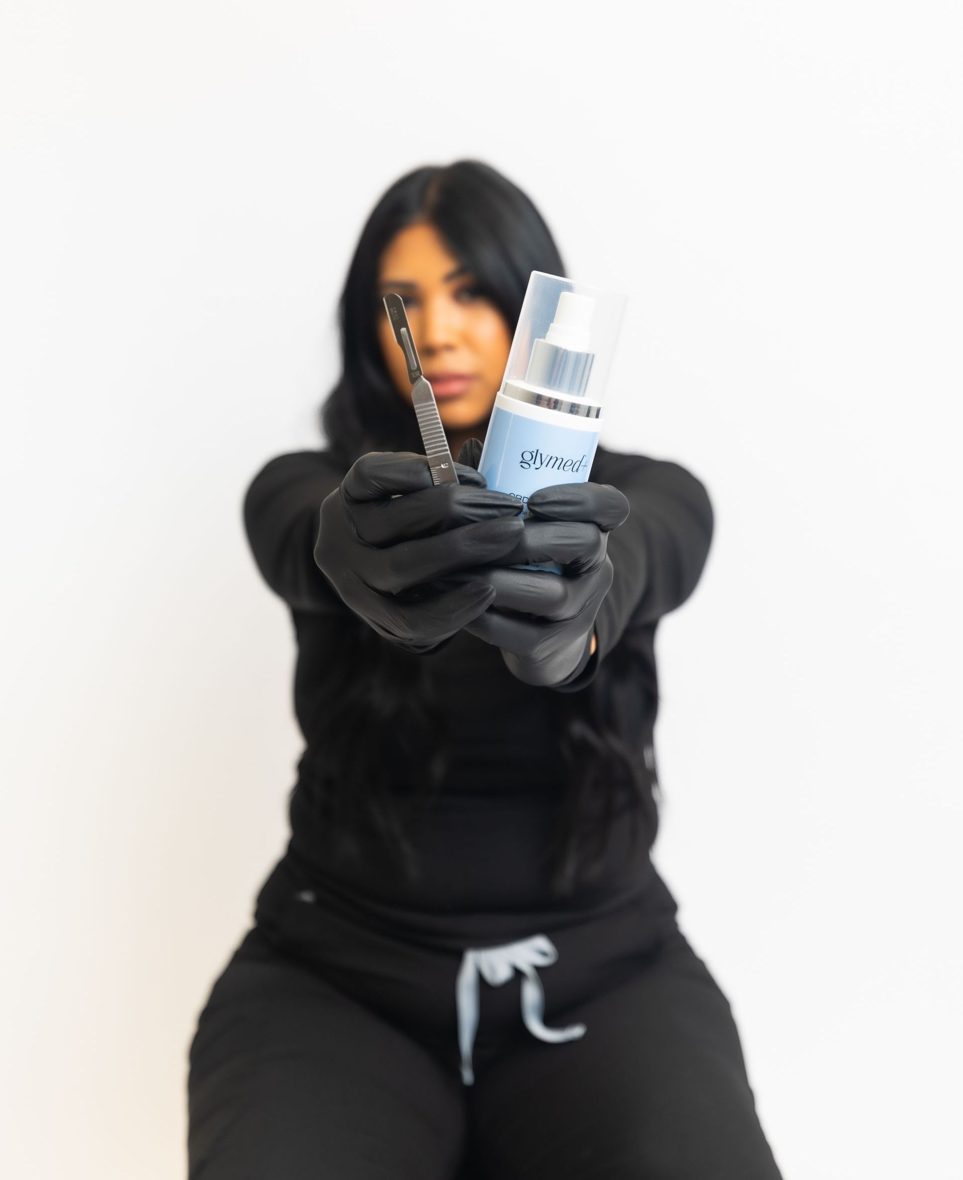 A woman in black gloves is holding a spray bottle