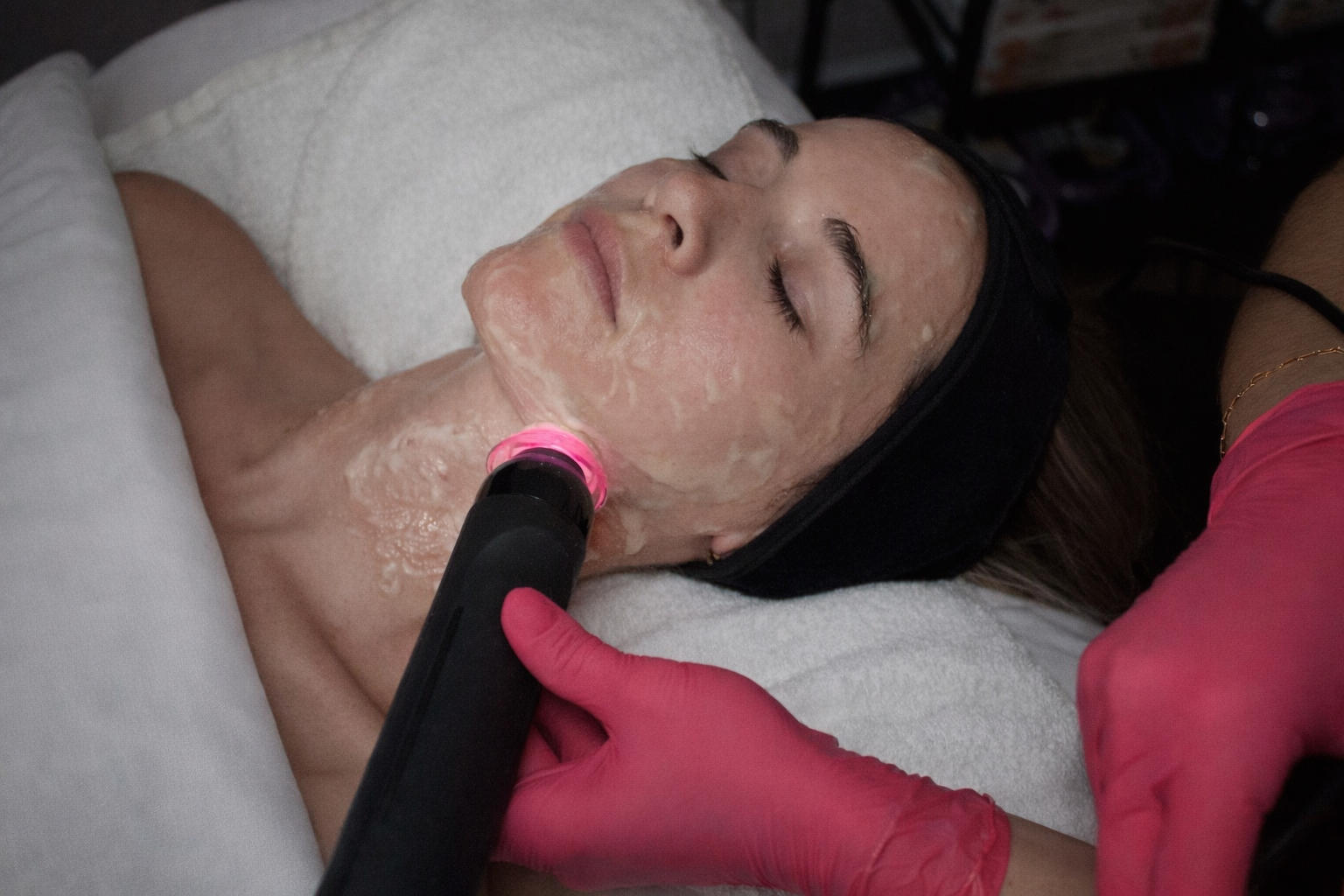 A woman is smiling and touching her face with her hands.