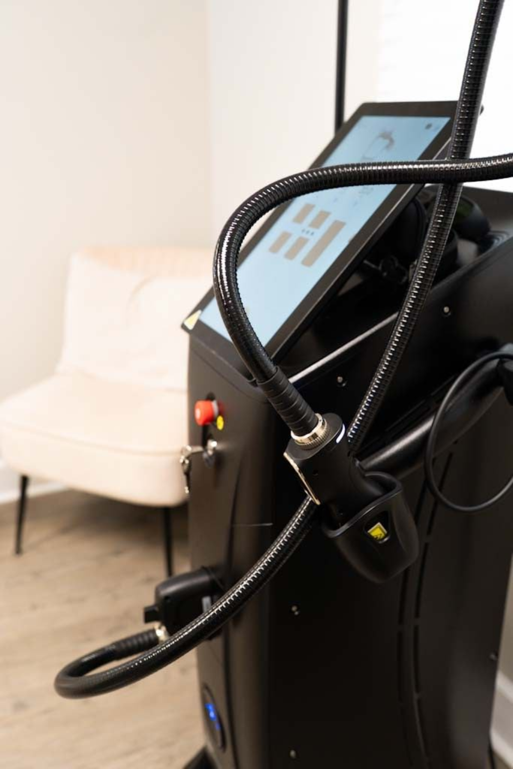 Two women in scrubs are standing next to a machine.