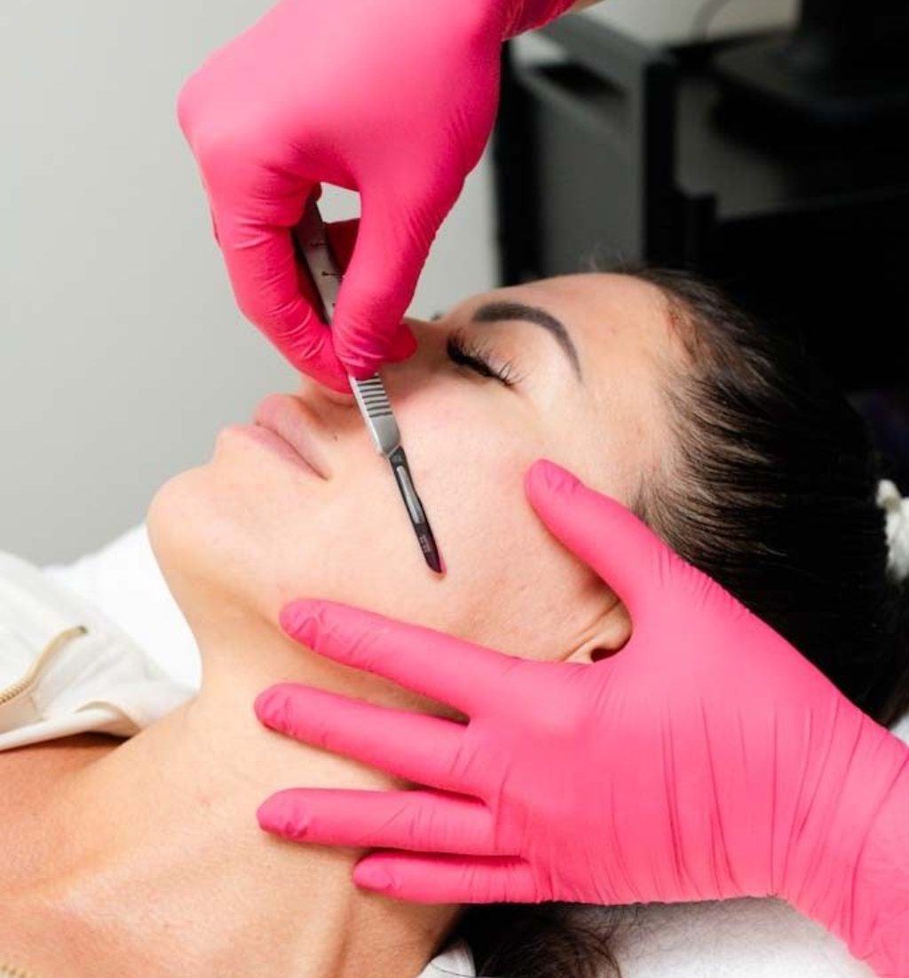 A woman is getting a facial treatment with cotton swabs.