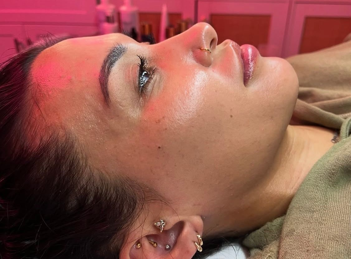 A woman is laying on a bed with steam coming out of her face.